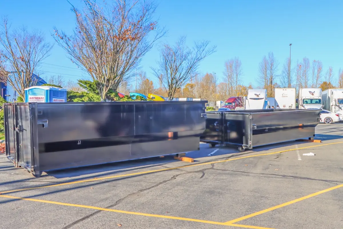 Professional dumpster rental service with roll-off container on residential driveway in Plumsted